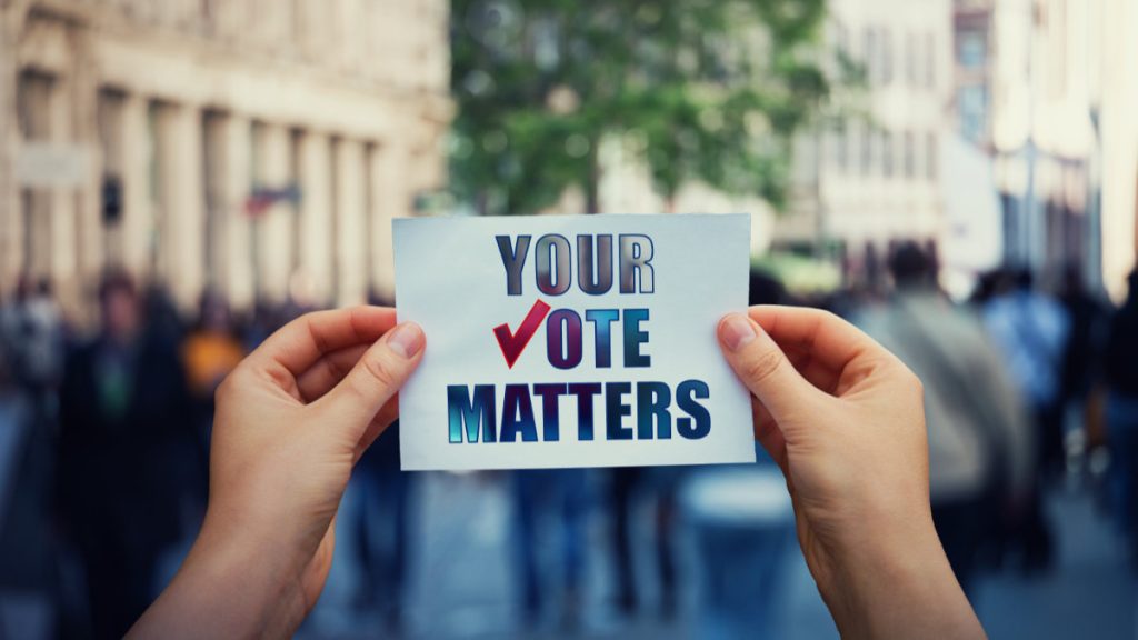 hands hold a paper sheet with the message your vote matters over